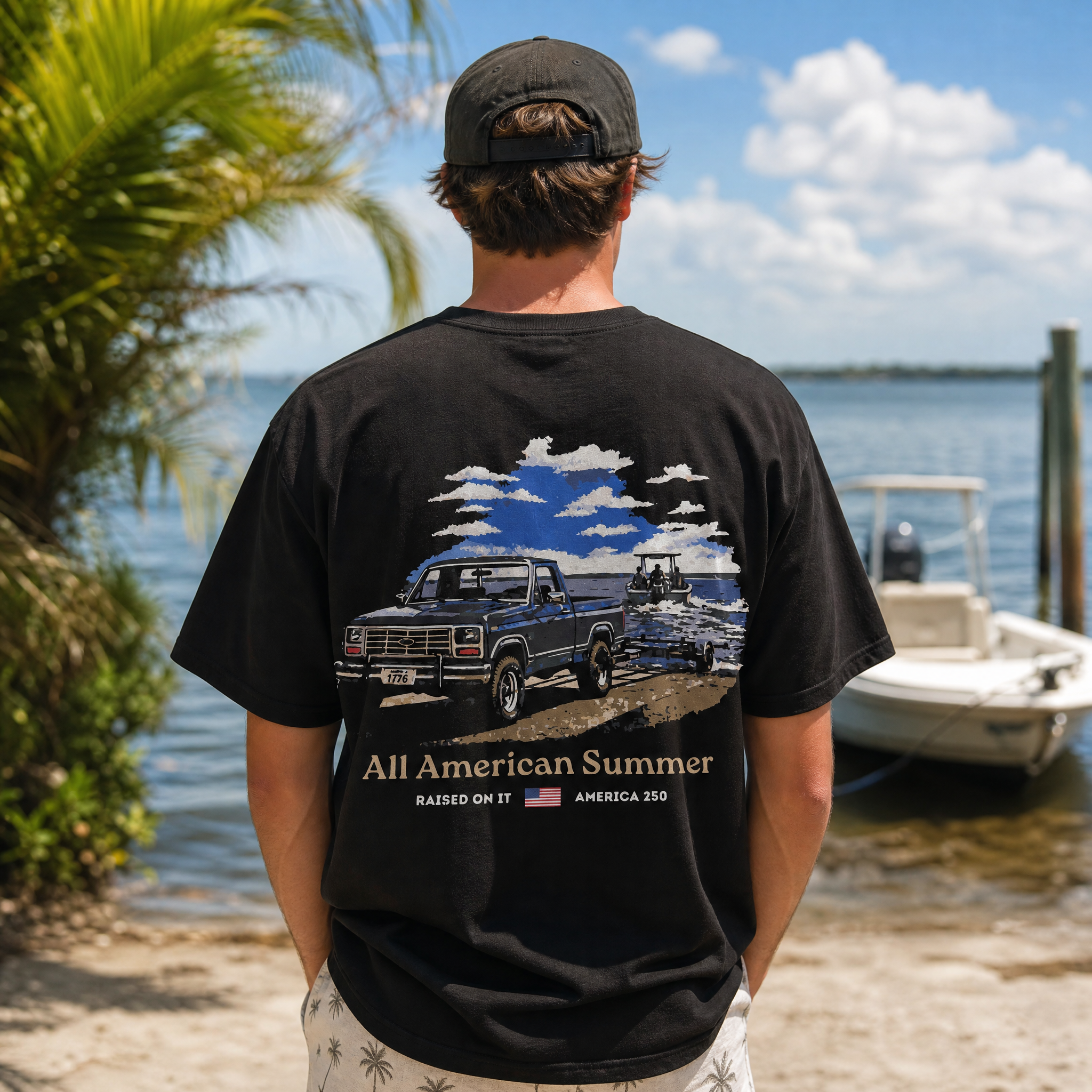 Man wearing the Raised On It All American Summer black tee at a Florida boat ramp, full back design visible