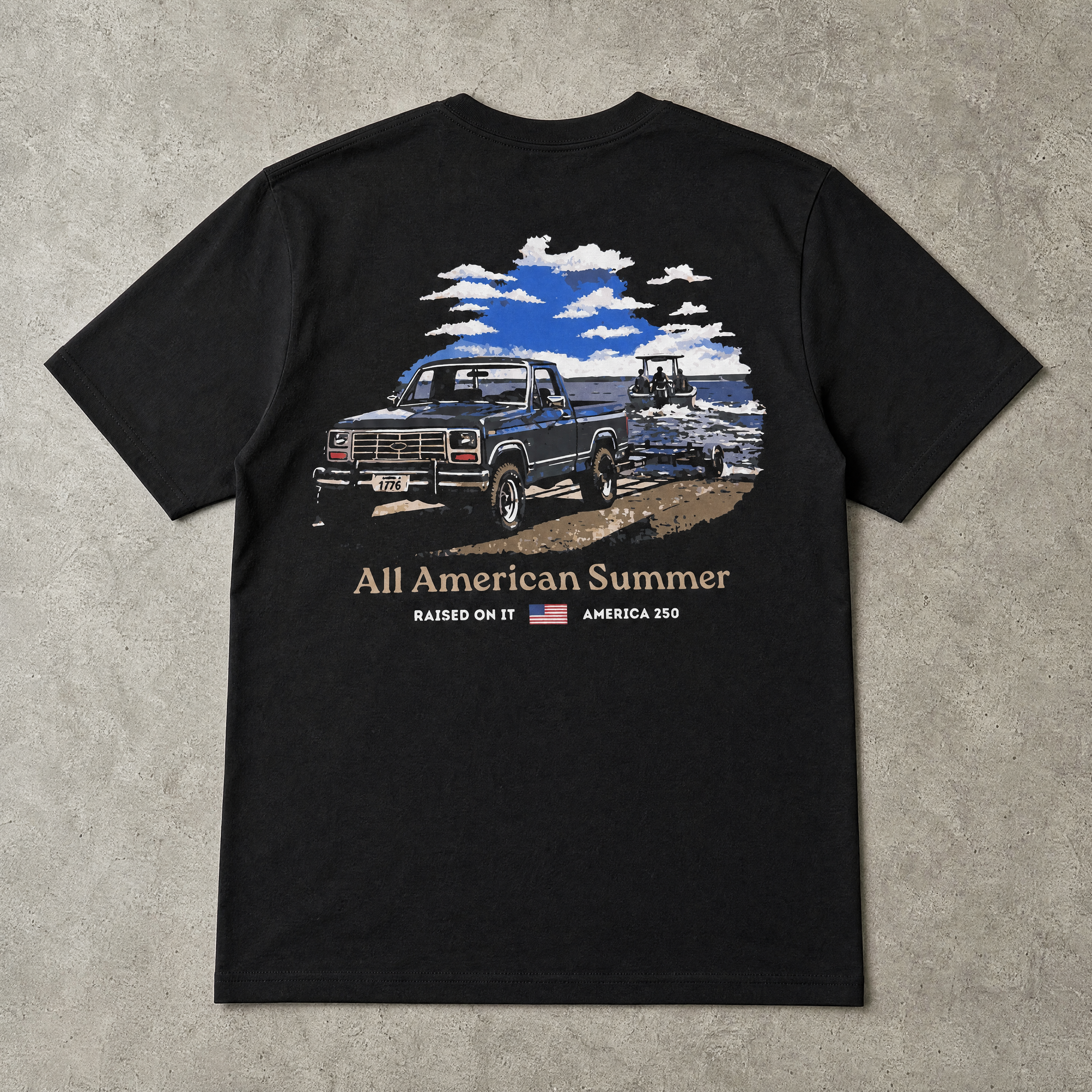 Raised On It All American Summer black tee back design, flat-lay on concrete